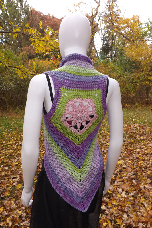 A crochet crop top vest with lotus flower design in shades of green, purple and pink.