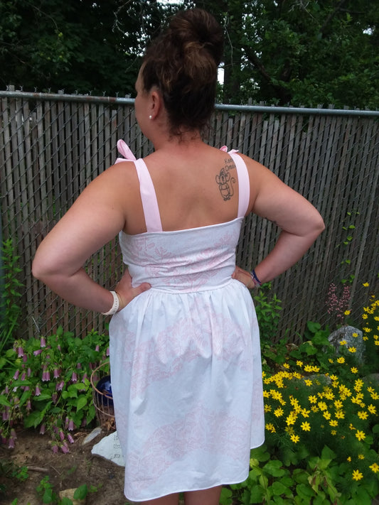 Rear view of a pink and white floral, summer dress created with repurposed textiles