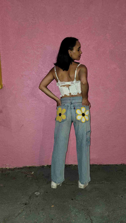 a woman standing in front of a pink wall.