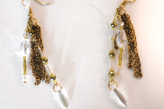 A pair of gold tassel earrings with clear crystals.