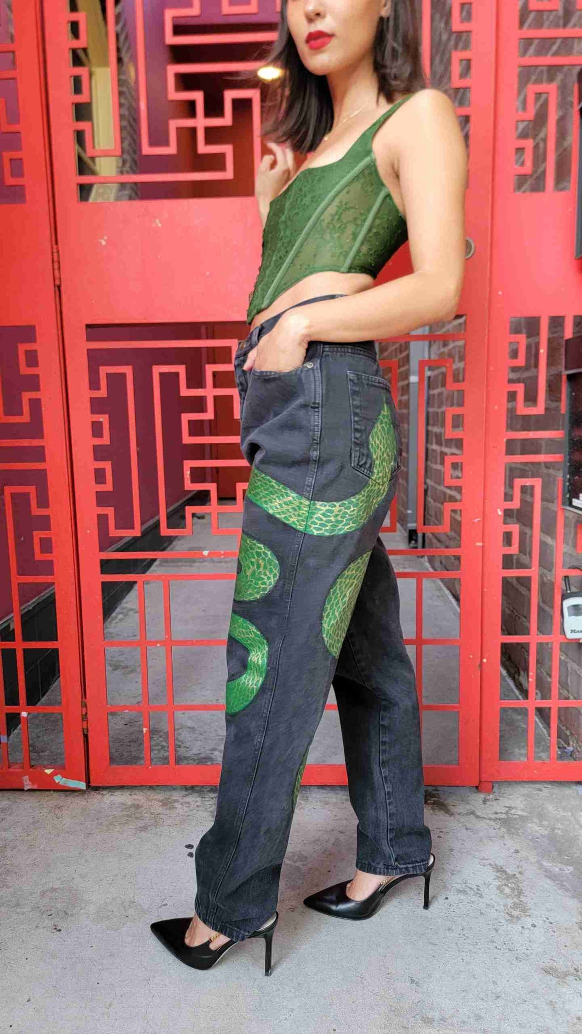 a woman standing in front of a red wall.