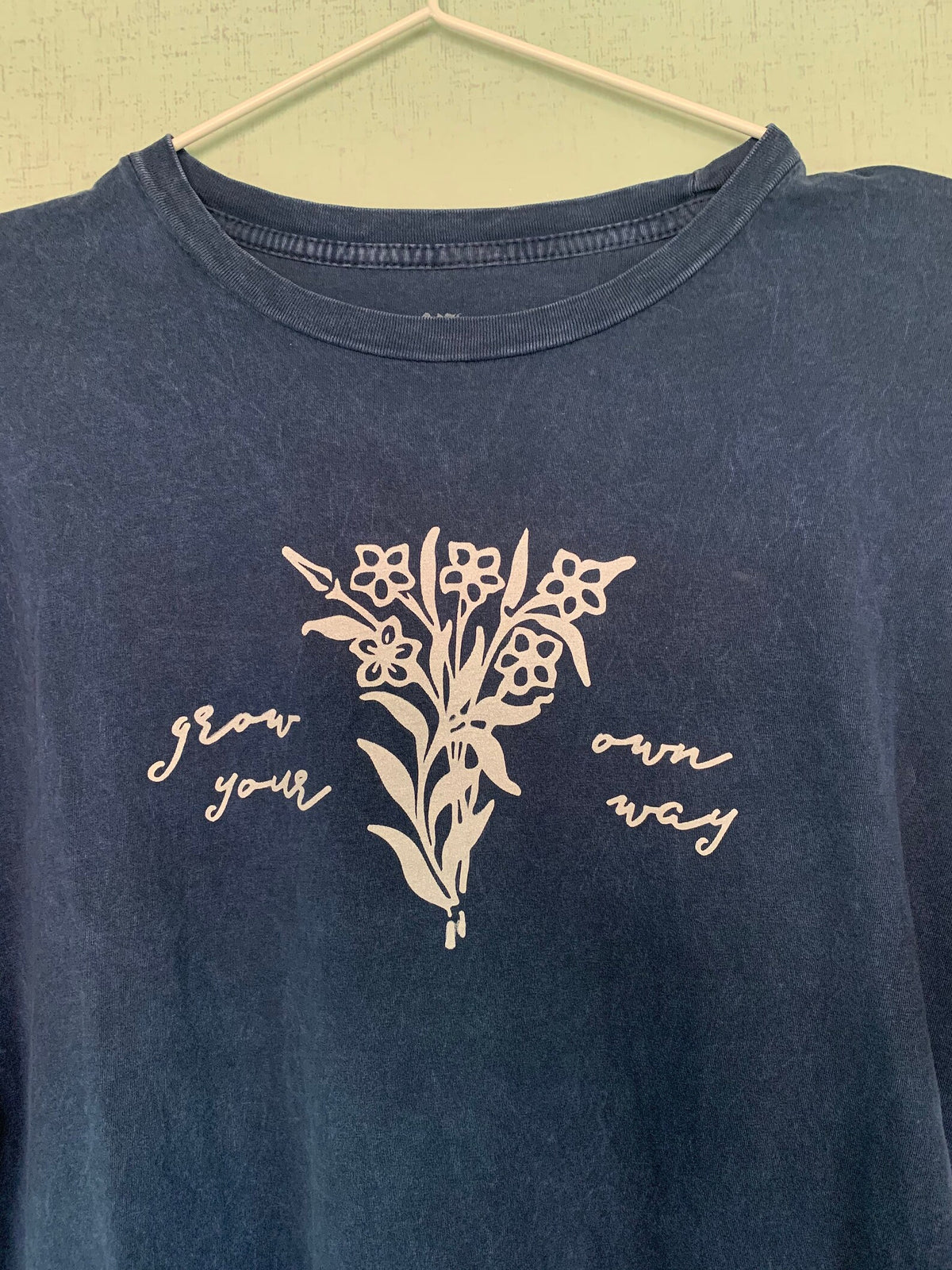 A blue t - shirt with flowers on it.