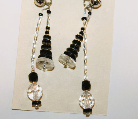 A pair of earrings with black and clear beads.