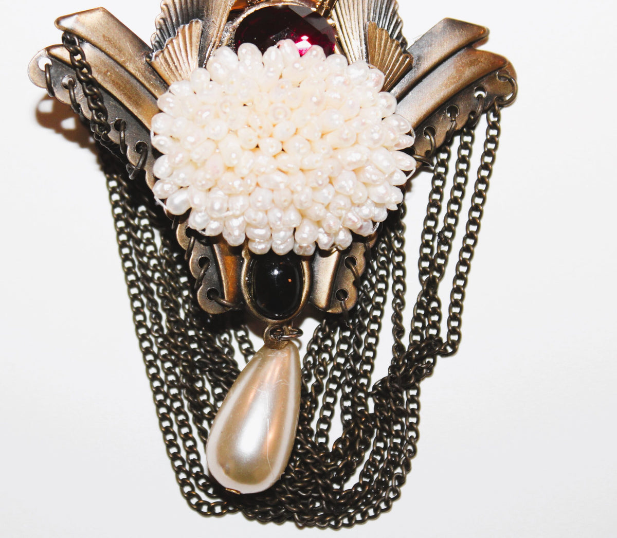 A necklace with a flower and pearls on it.