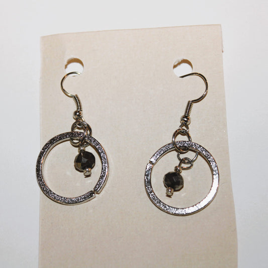 A pair of silver dangle earrings with black stones.