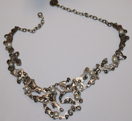 segmented silver tone necklace on a white surface