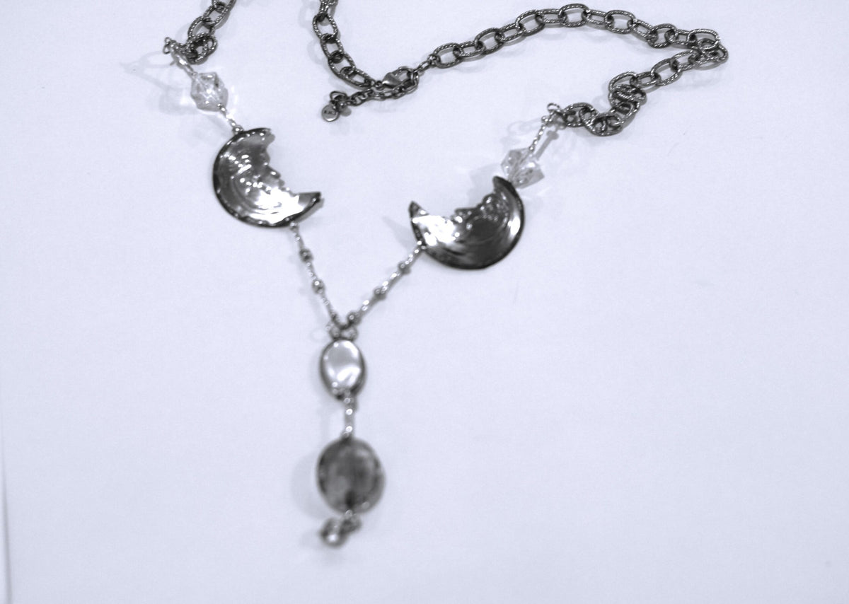 A silver necklace with a moon and stars on it.