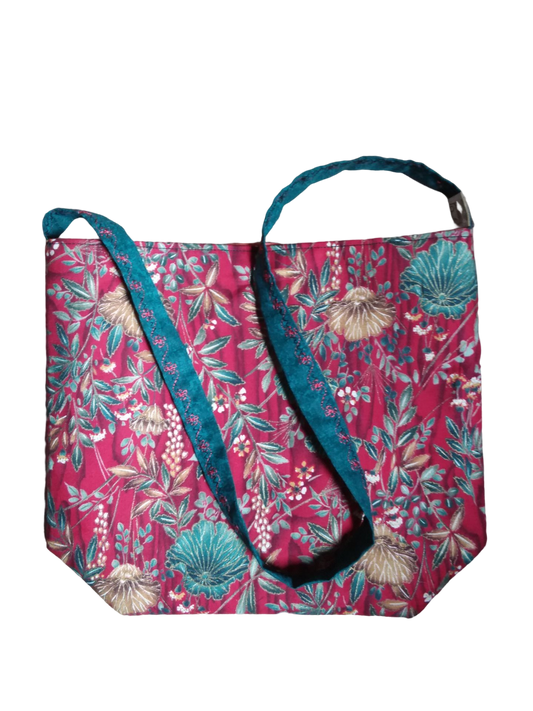 An upcycled fabric bag with bold colors and floral design