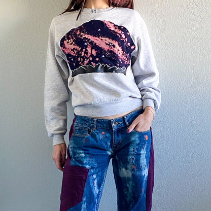 A woman wearing a sweatshirt and jeans.