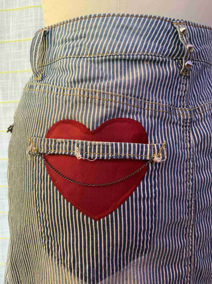 a red heart is in the pocket of a pair of jeans.