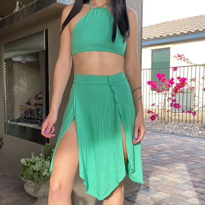 A woman in a 1of1 mint green petal skirt is standing outside.