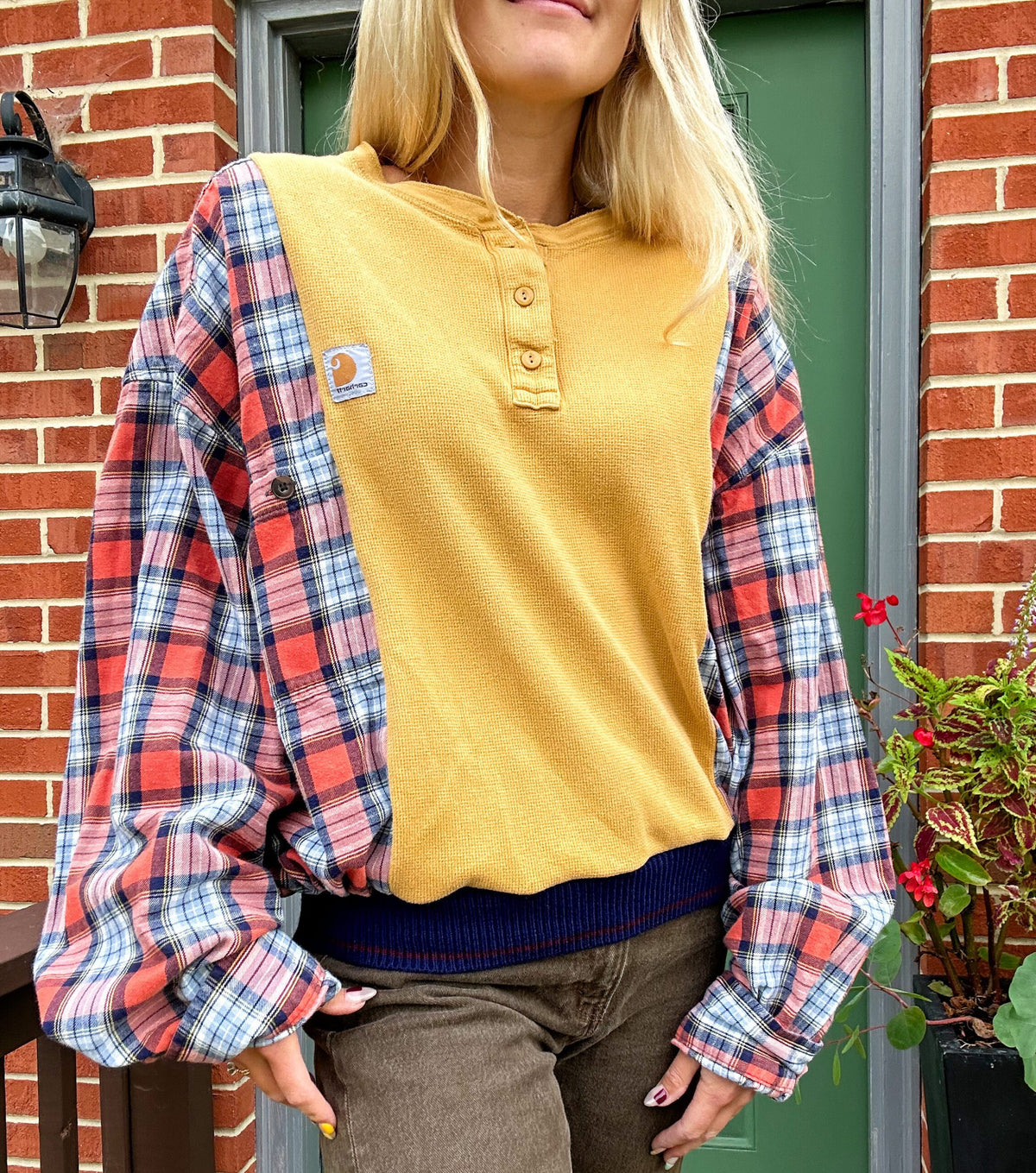 A blonde woman wearing a yellow and blue plaid shirt.