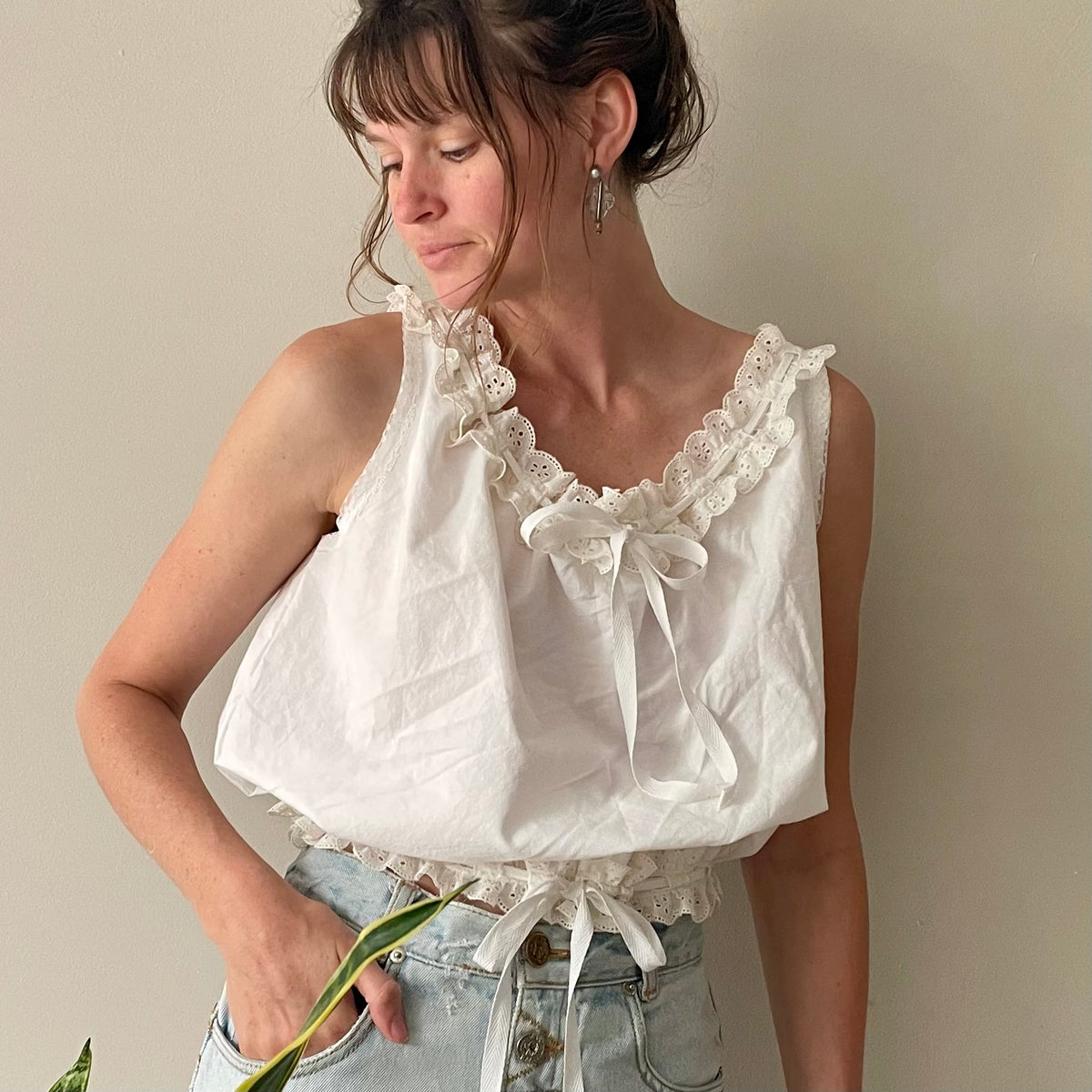 a woman in a white top holding a flower.