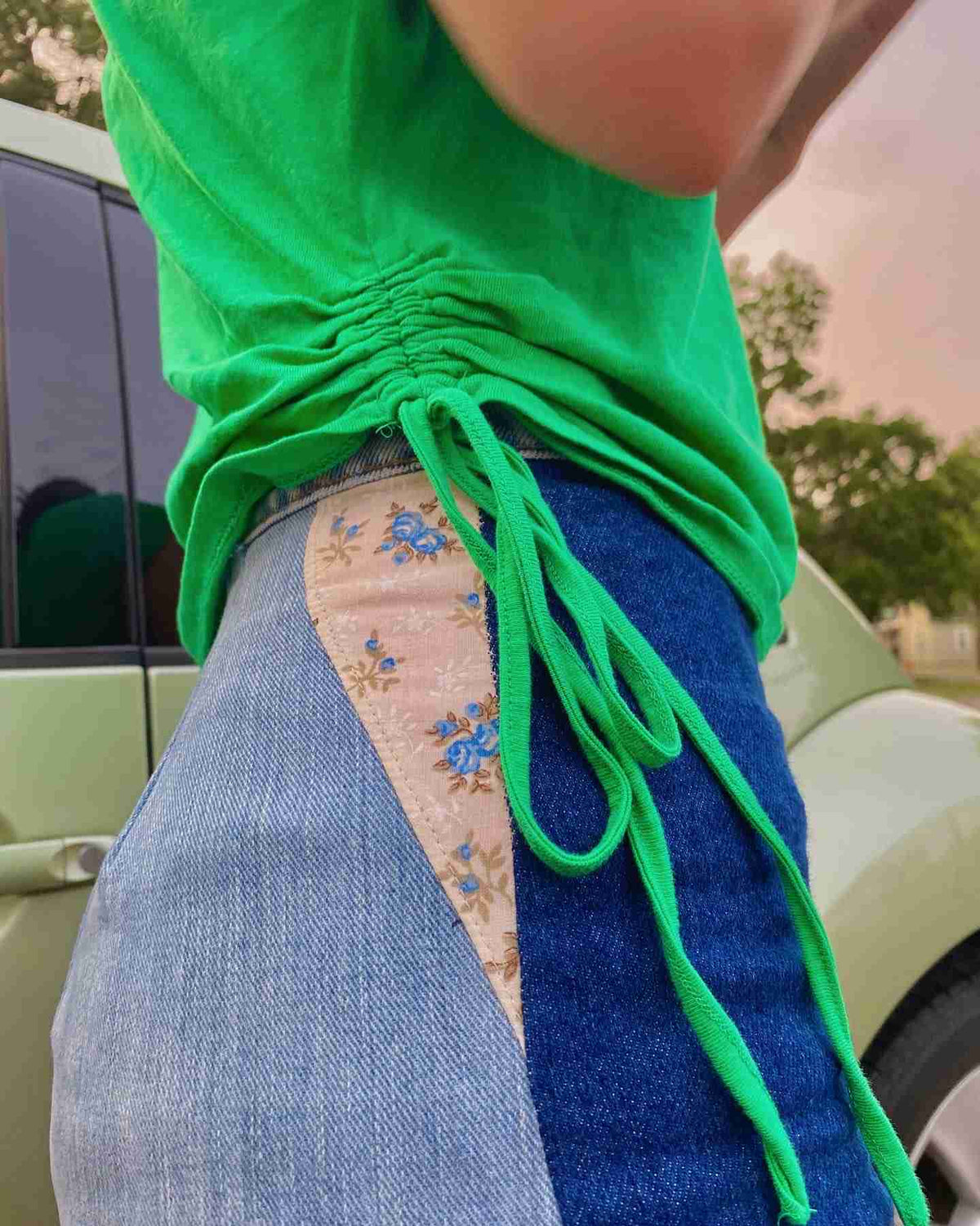 a person wearing a green shirt and blue jeans.
