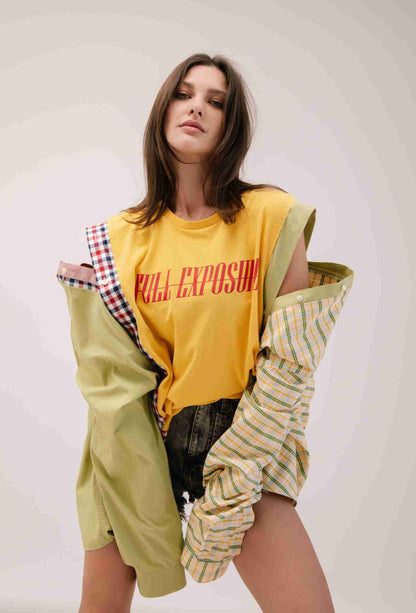 a woman in a yellow shirt and plaid shorts.