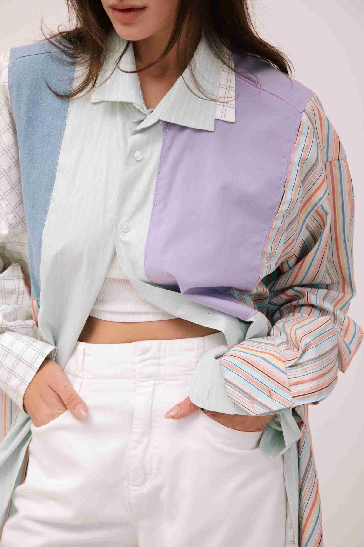 a woman wearing a colorful shirt and white pants.