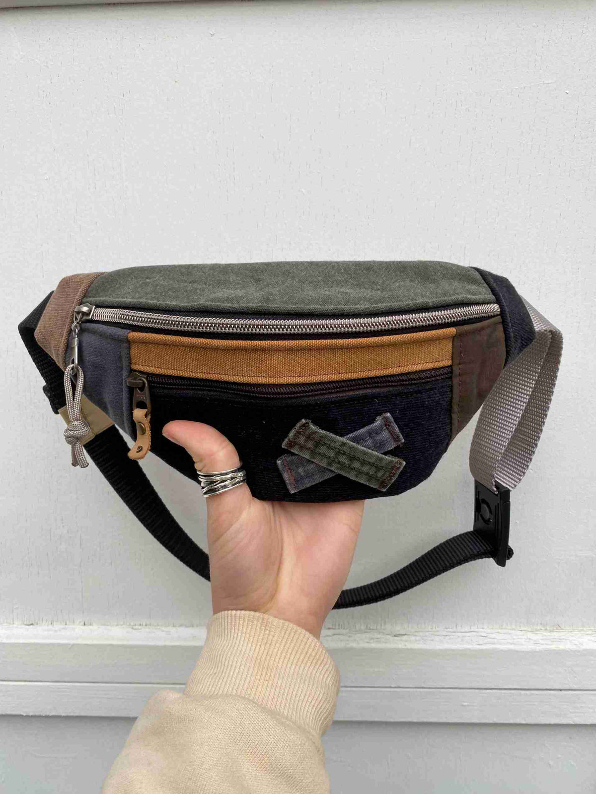 a person holding a small black and brown bag.