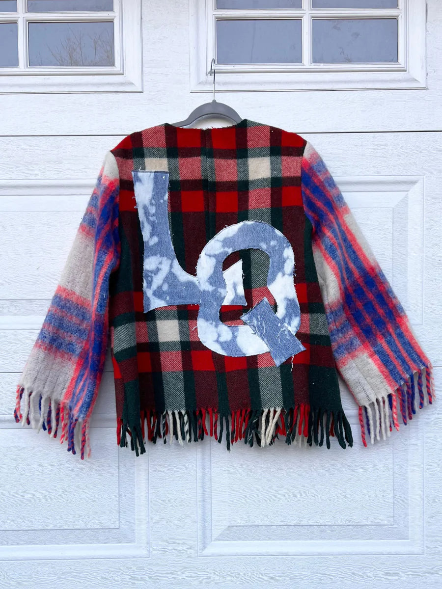 a plaid coat hanging on a garage door.