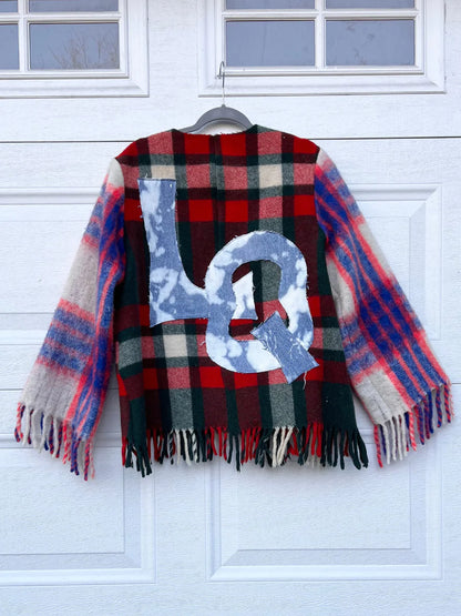 a plaid coat hanging on a garage door.