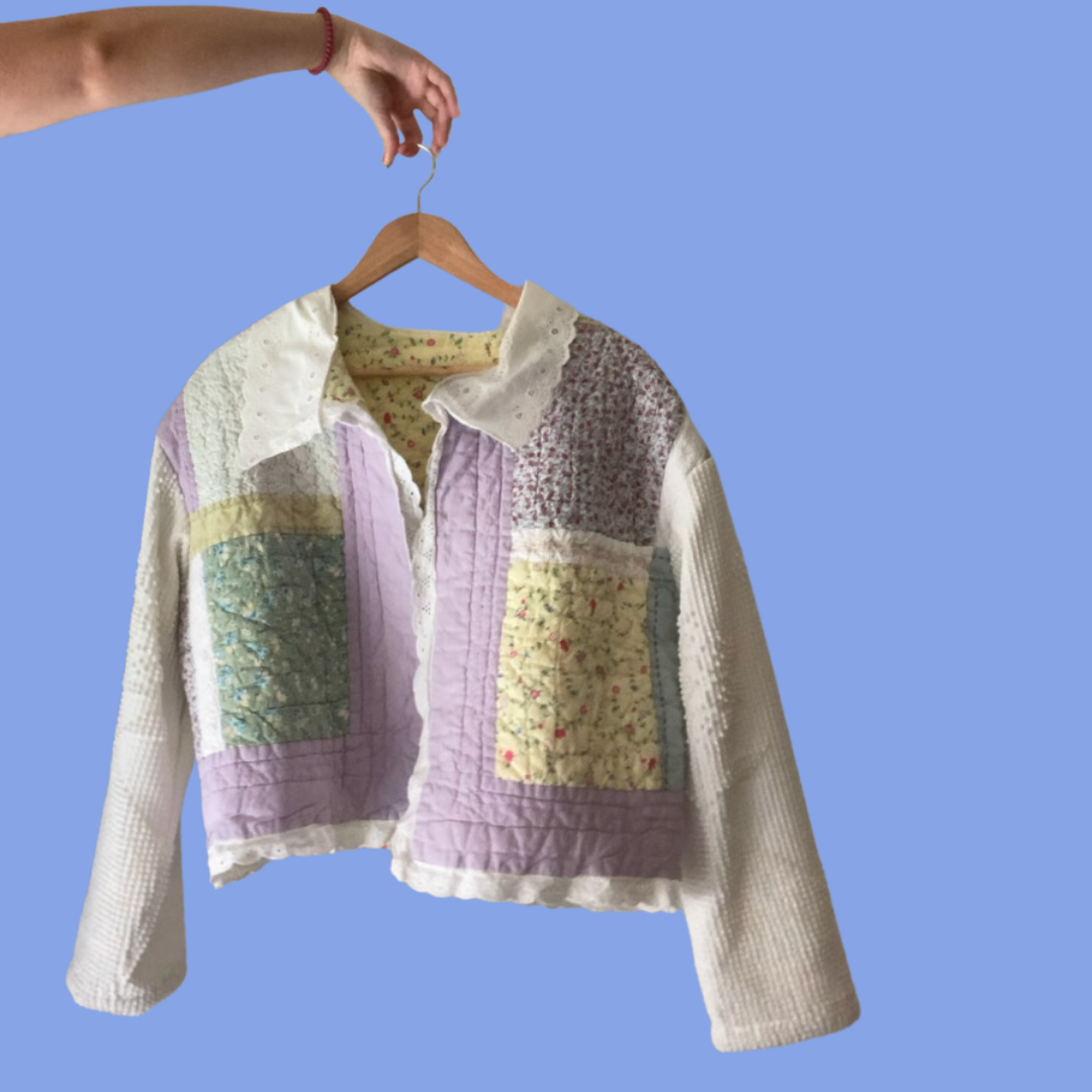 A woman is holding a jacket on a hanger.