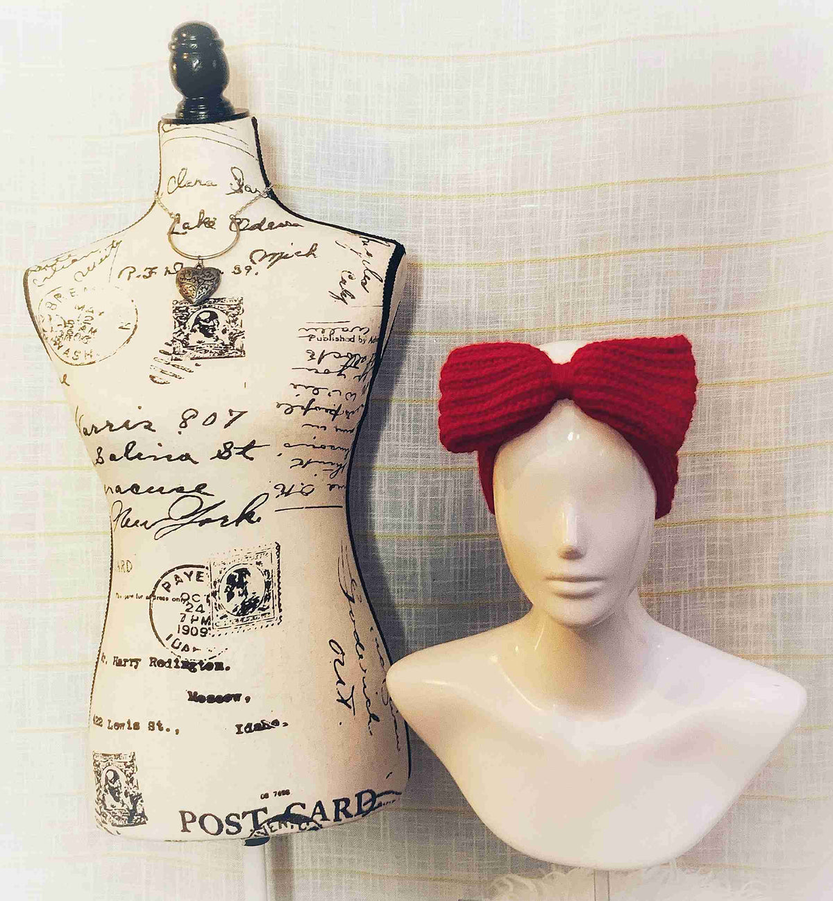 a white mannequin with a red bow on top of it.