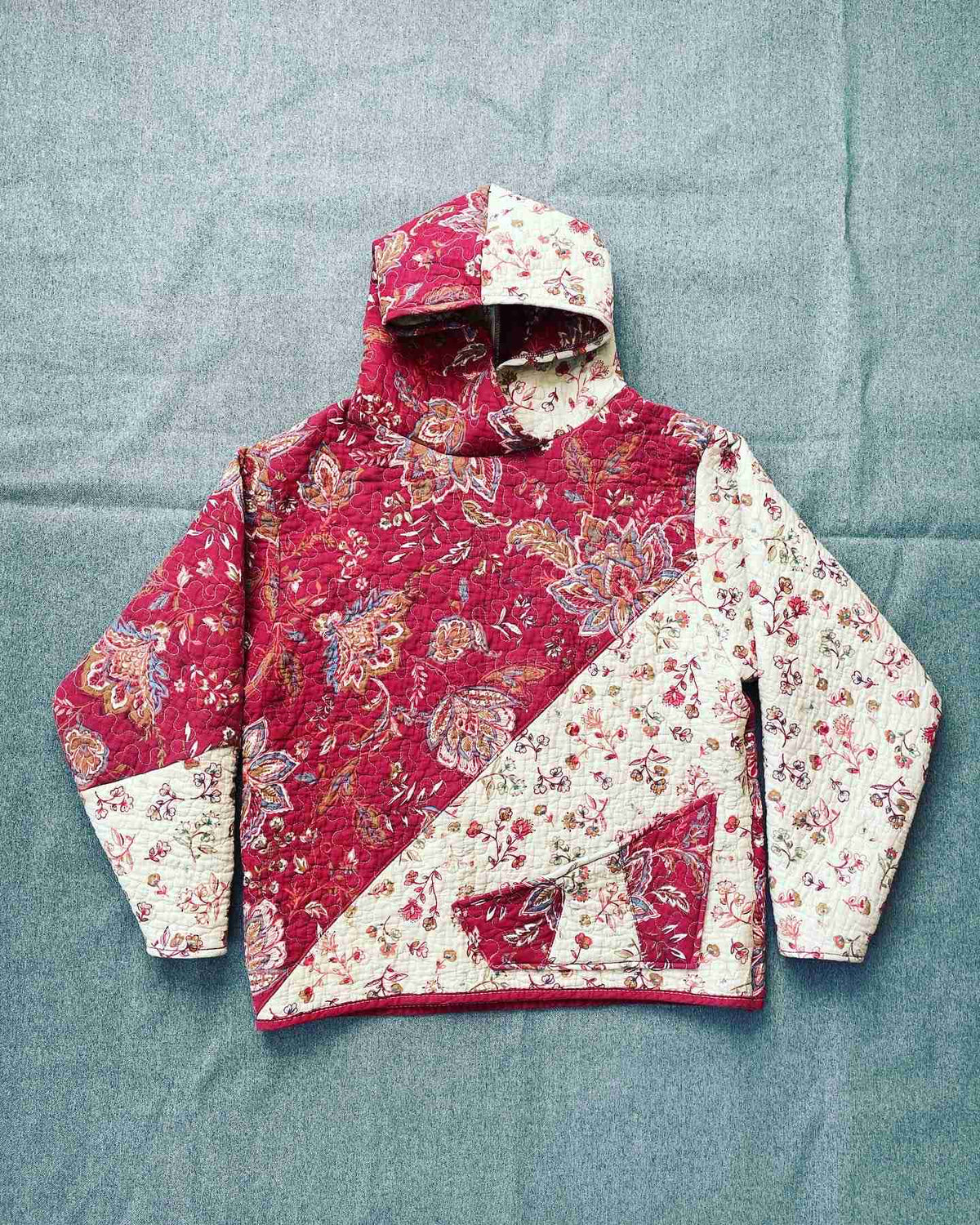 a red and white jacket sitting on top of a bed.