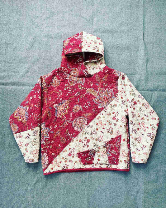 a red and white jacket sitting on top of a bed.