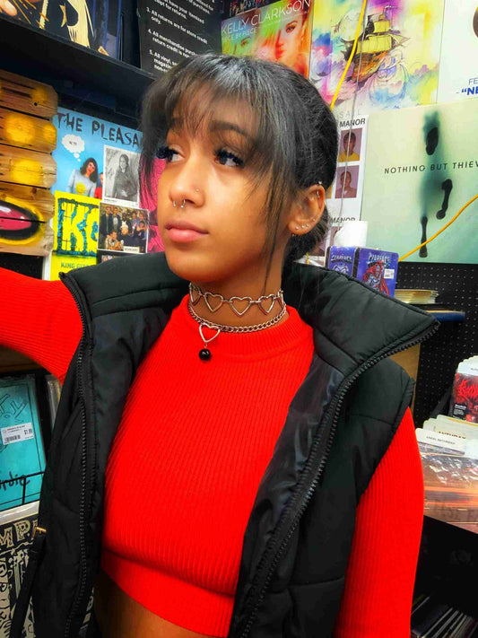 a woman in a red top and black vest.