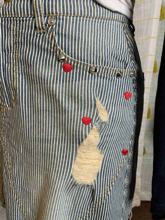 a person wearing a stripped skirt with red hearts on it.