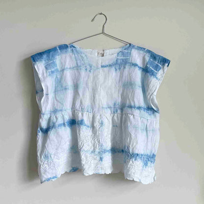 a white and blue shirt hanging on a hanger.