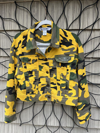a yellow camouflage jacket hanging on a wall.
