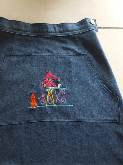 An Embroidered Dark Wash Kangaroo Pocket Mini Skirt with a picture of a cat on it.