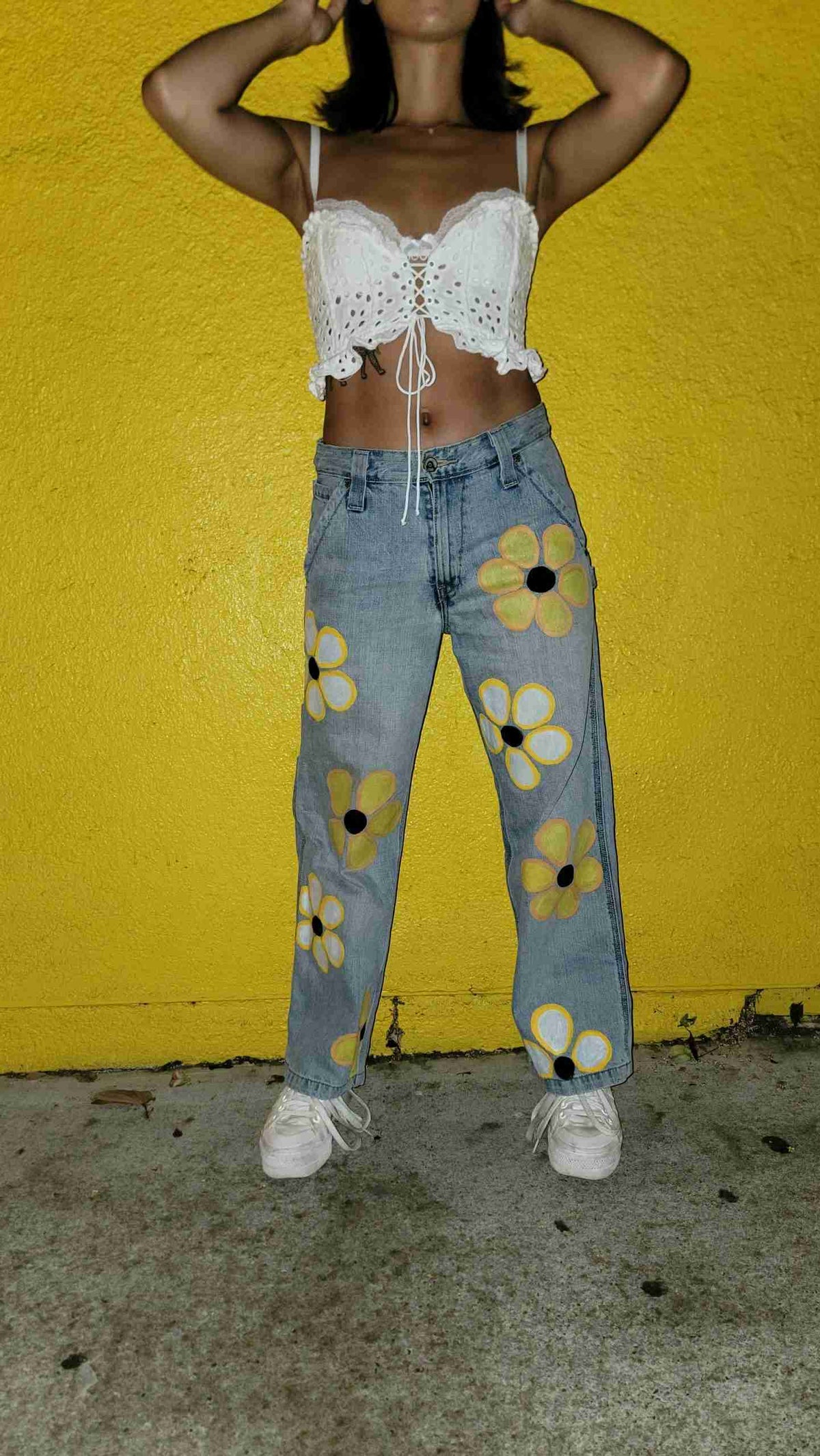 a woman standing in front of a yellow wall.