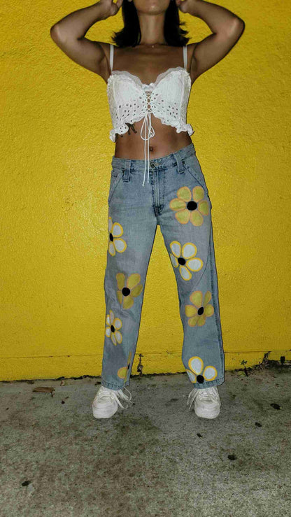 a woman standing in front of a yellow wall.