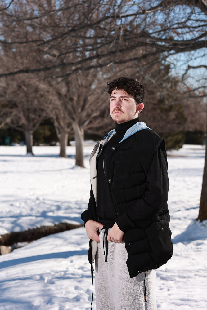 a man standing in the snow wearing a black jacket.