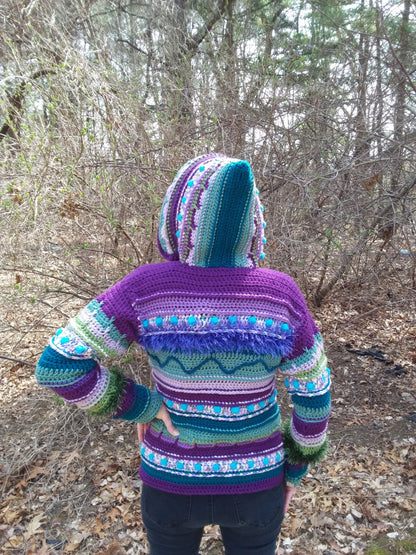 A woman wearing a purple sweater in the woods.