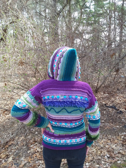 A woman wearing a purple sweater in the woods.