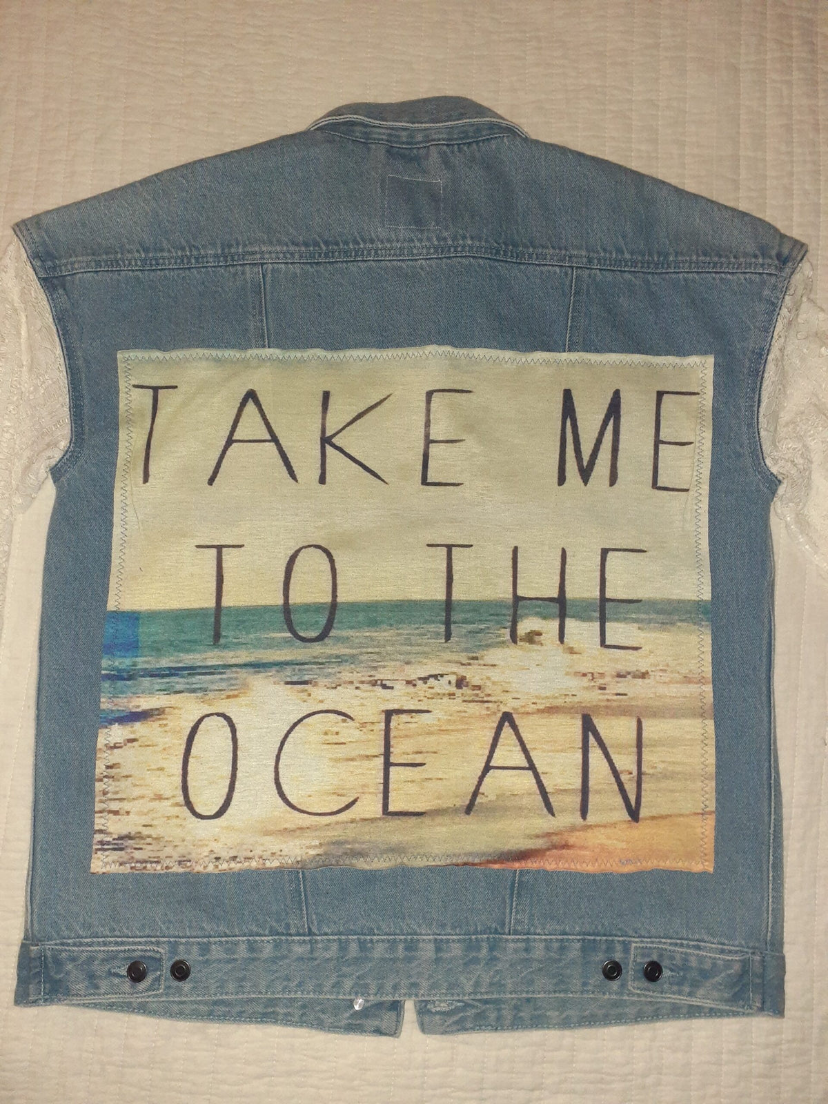 Take Me To The Ocean upcycled denim & lace jacket with a message written on it.