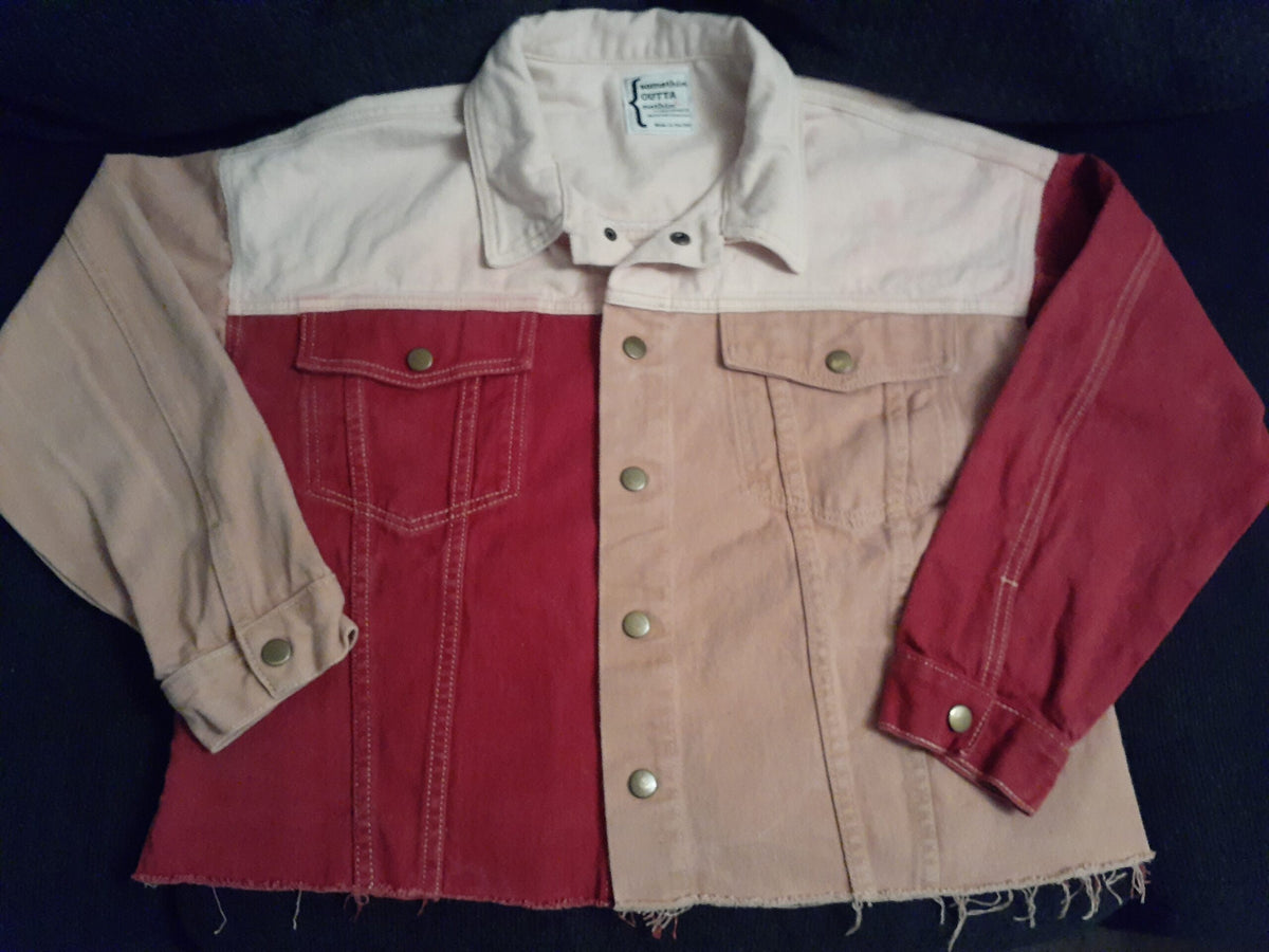 A Skull & Flowers Frida Kahlo inspired pink color block denim jacket Large with a red and white jacket on it.