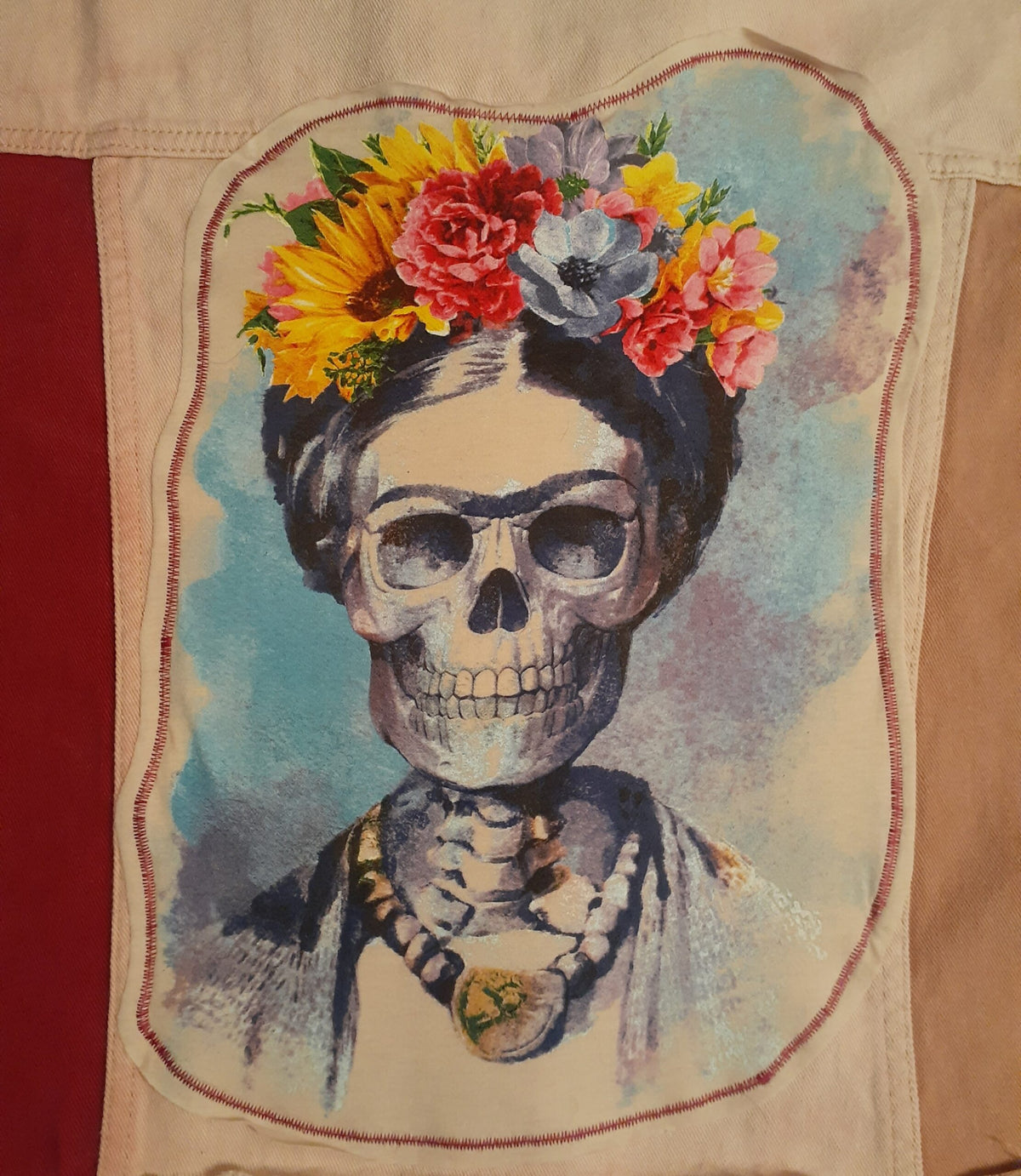 A Skull & Flowers Frida Kahlo inspired pink color block denim jacket Large with a painting of a woman with flowers in her hair.