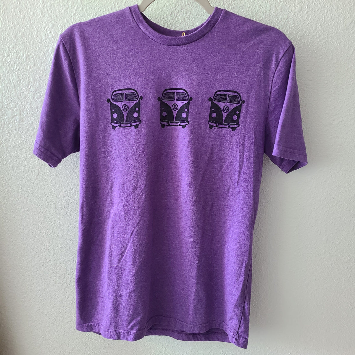 a purple t - shirt with three vw vans on it.