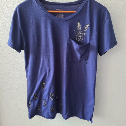 a blue t - shirt with a pocket on it.