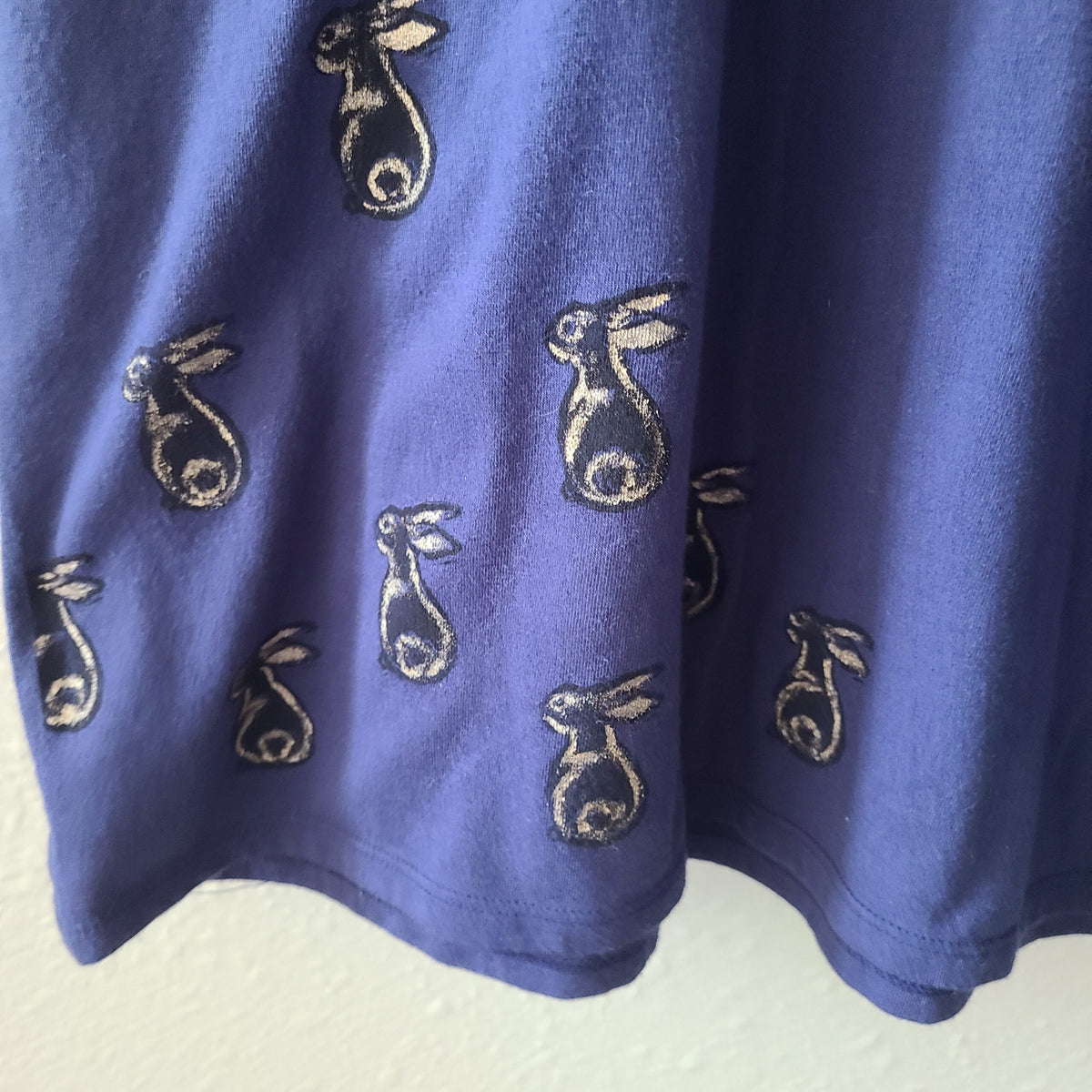 a blue shirt with embroidered rabbits on it.