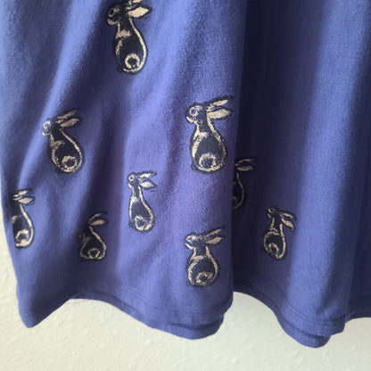 a blue shirt with embroidered rabbits on it.