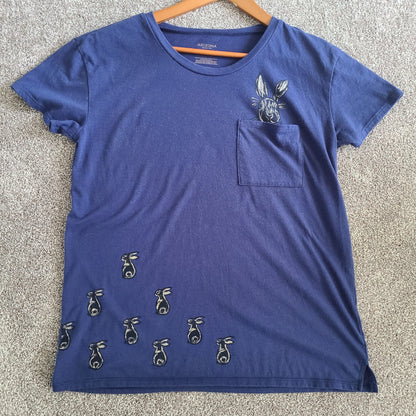 a blue t - shirt with a rabbit on the pocket.