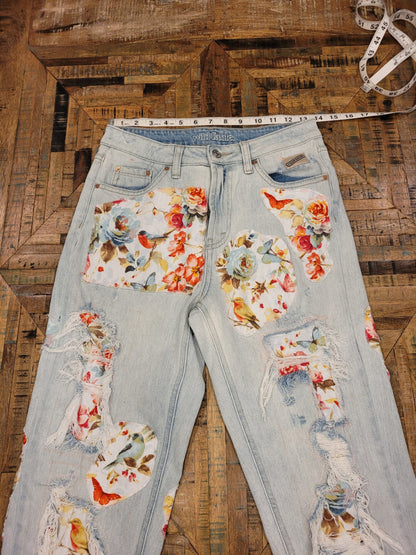 a pair of distressed jeans with flowers on them.