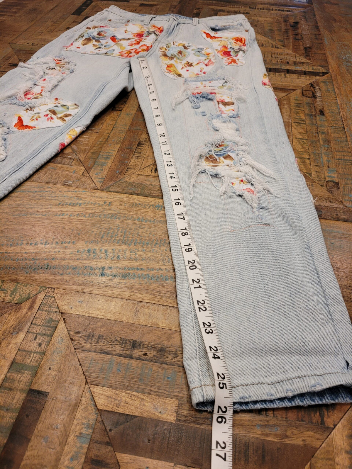 a pair of jeans with a measuring tape on the floor.