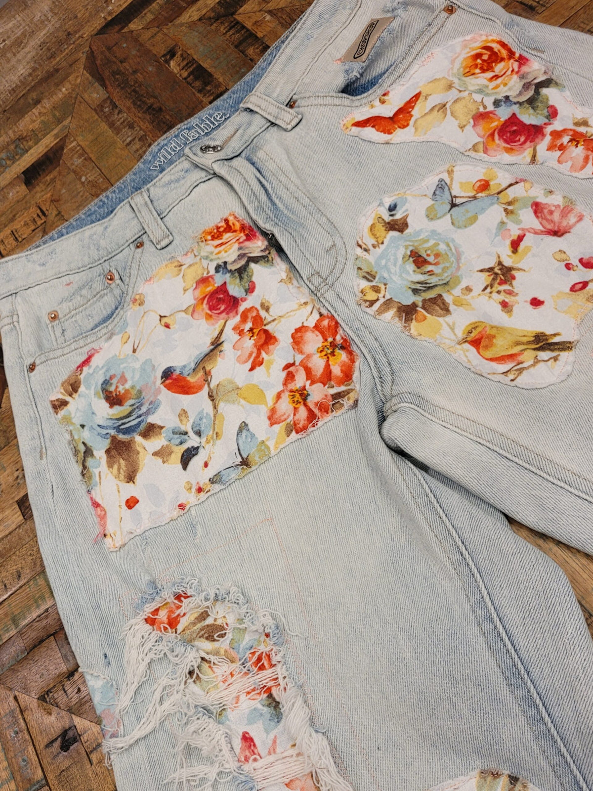 a pair of jeans with flowers on them.