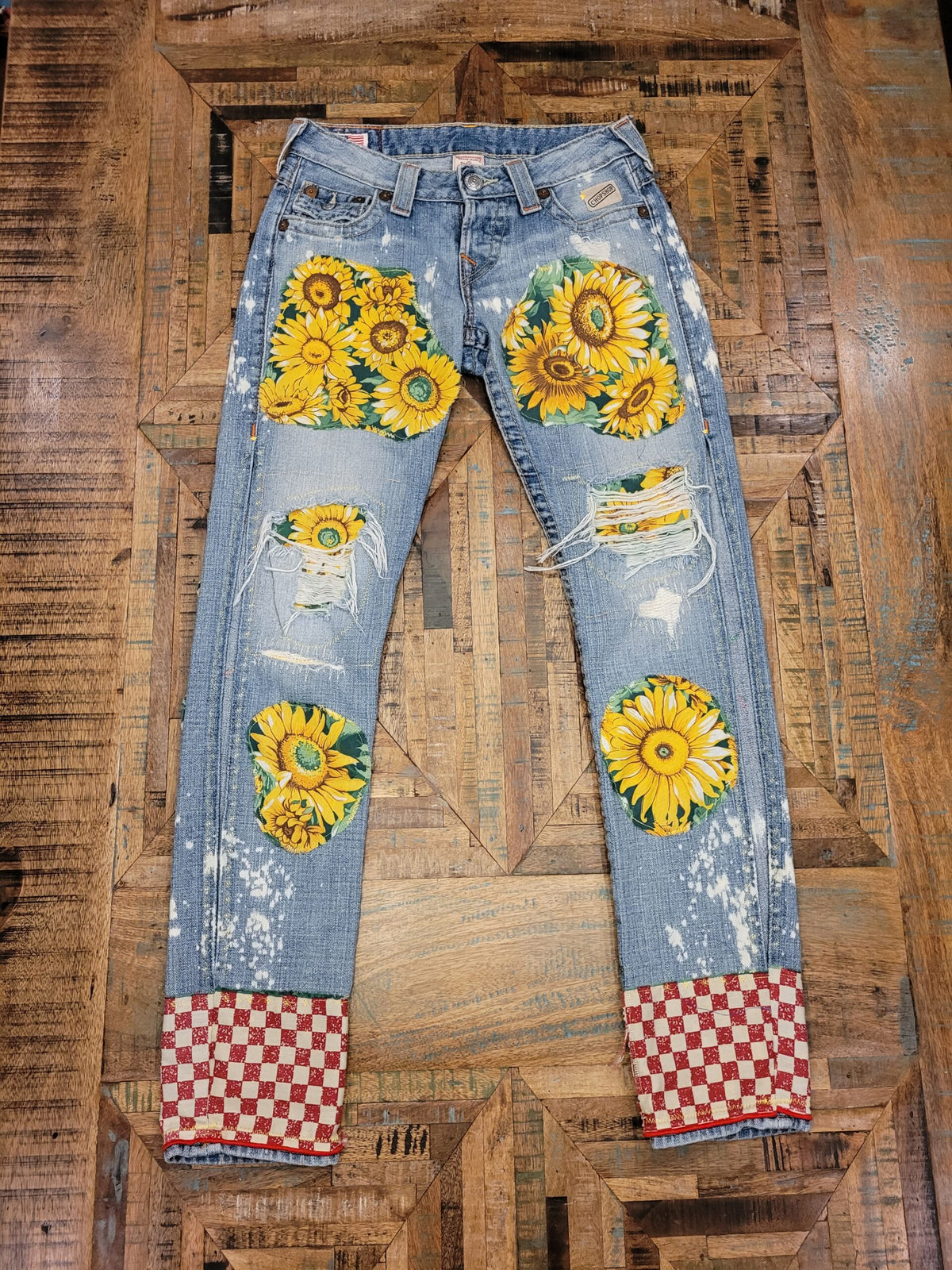 a pair of jeans with sunflowers on them.