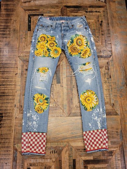 a pair of jeans with sunflowers on them.